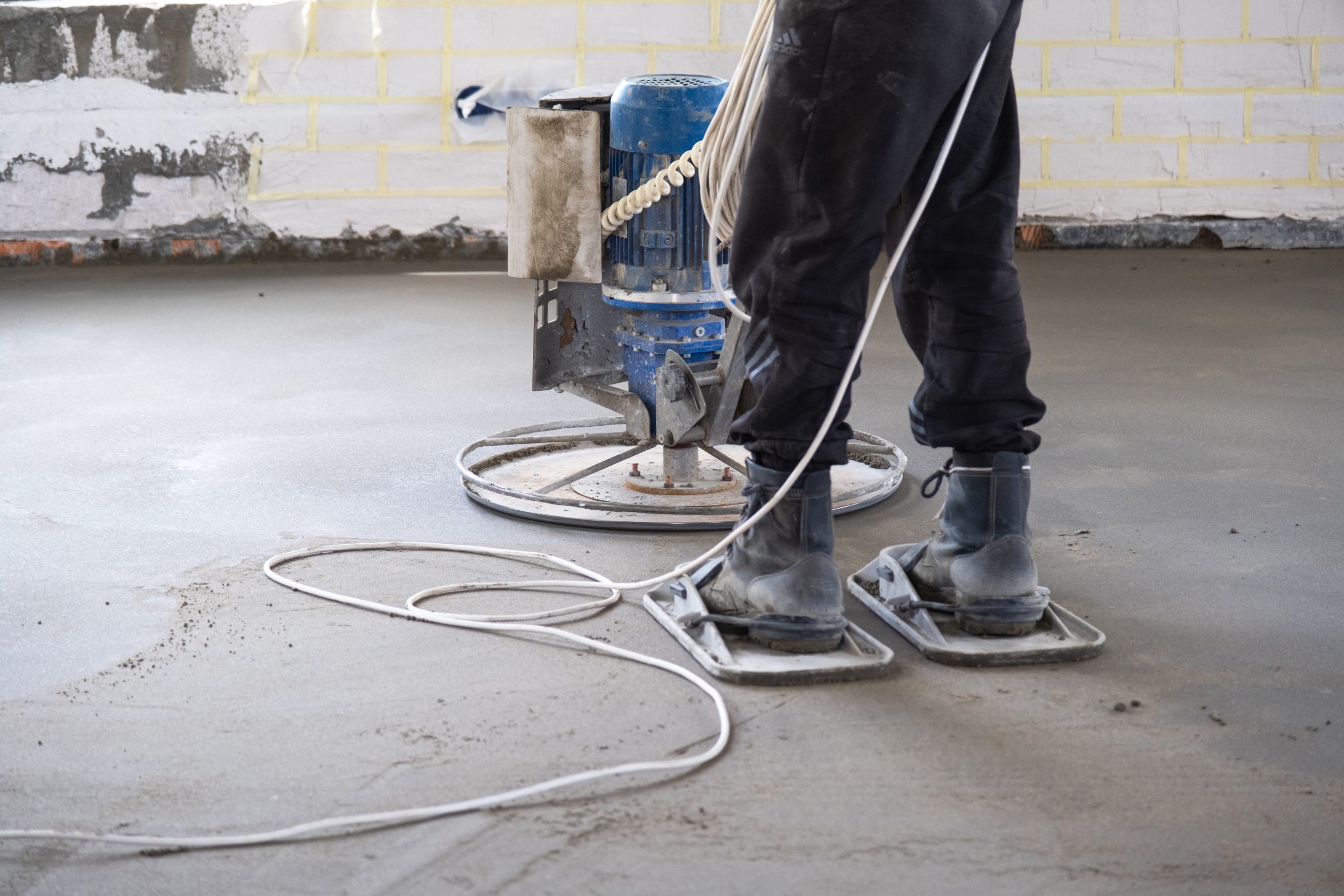 Ramming and grinding of semi-dry floor screed by a machine with